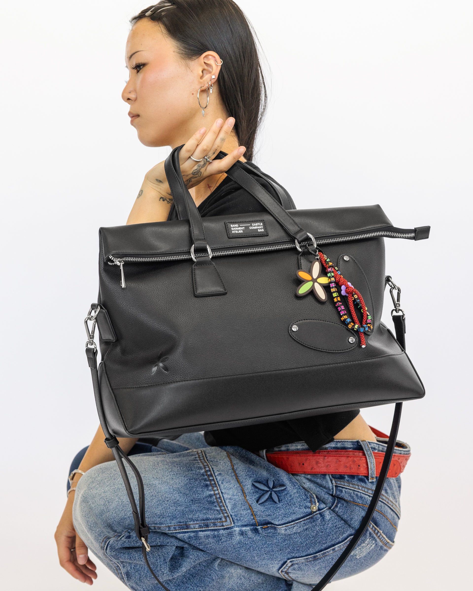 Atelier Bag in Coal, worn by model crouching — Sand Castle Atelier