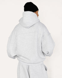 Model wearing Heritage Pullover Hoodie in heather grey, back view — Sand Castle Atelier