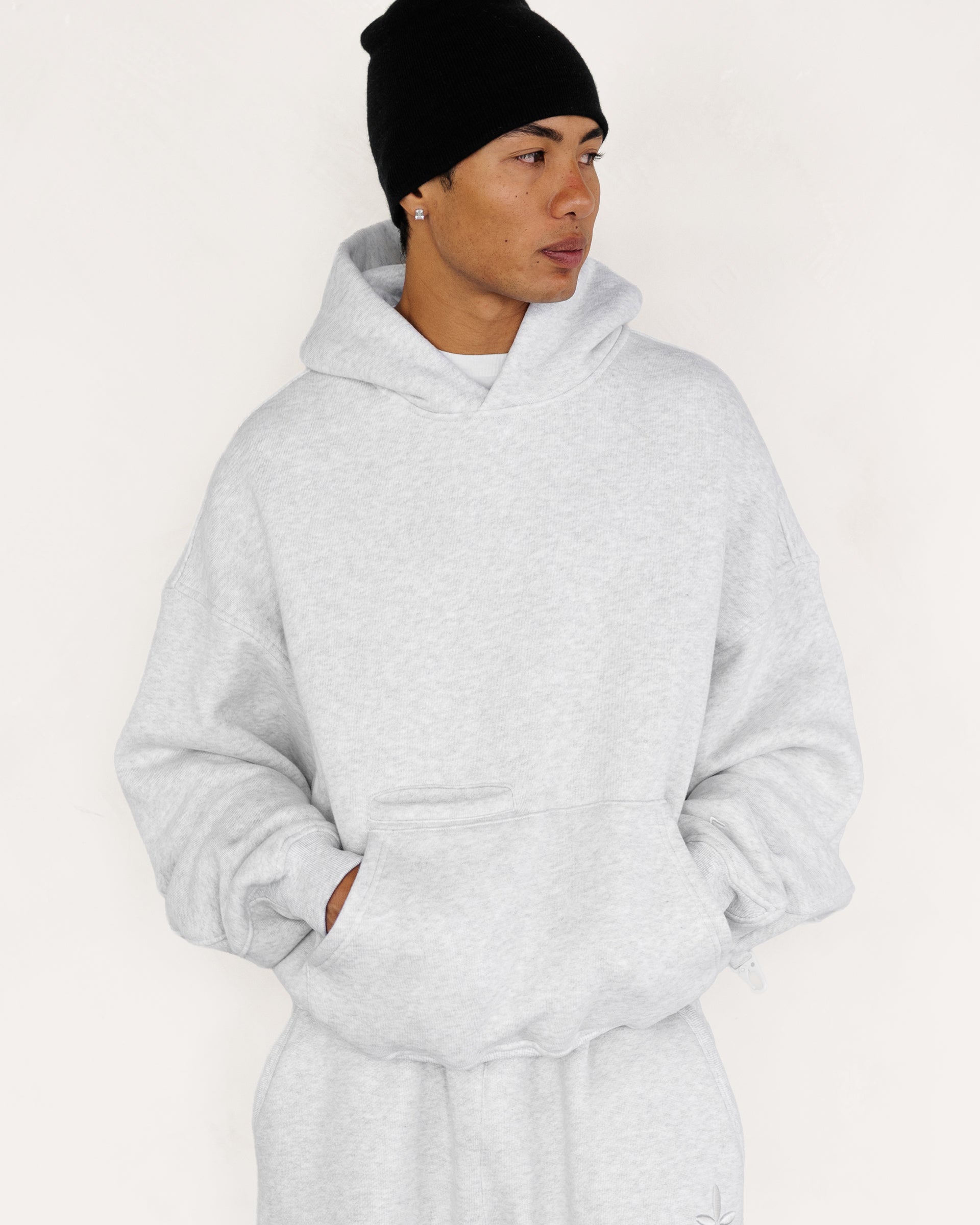 Model wearing Heritage Pullover Hoodie in heather grey, front view — Sand Castle Atelier